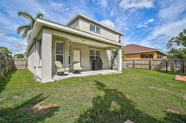 rear view of property with a patio area, central air condition unit, and a lawn