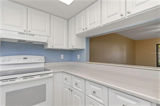 kitchen with white electric stove and white cabinets