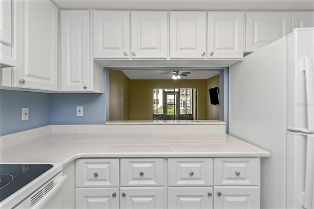 kitchen featuring ceiling fan, white fridge, and white cabinets