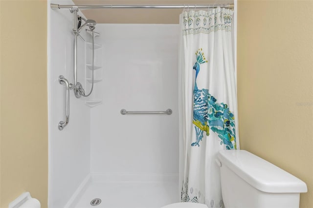 bathroom featuring toilet and curtained shower