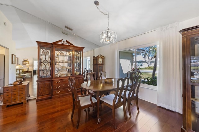 dining room with vaulted ceiling, dark hardwood / wood-style floors, and a chandelier