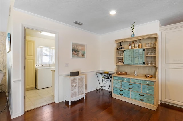 bar featuring hardwood / wood-style flooring, ornamental molding, washer / clothes dryer, and a textured ceiling