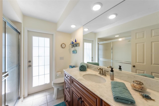 bathroom with walk in shower, vanity, toilet, and tile patterned flooring