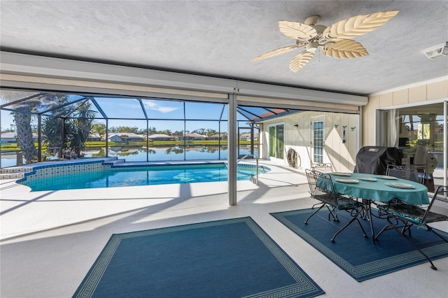 view of pool with a patio, glass enclosure, and a water view