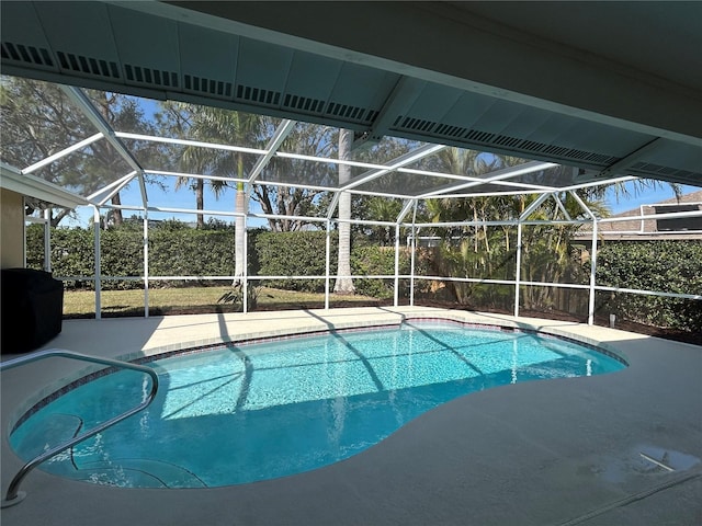 view of swimming pool featuring a patio and glass enclosure