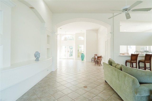 tiled living room featuring ceiling fan and french doors