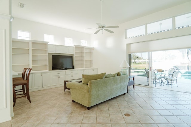 tiled living room featuring a towering ceiling and ceiling fan