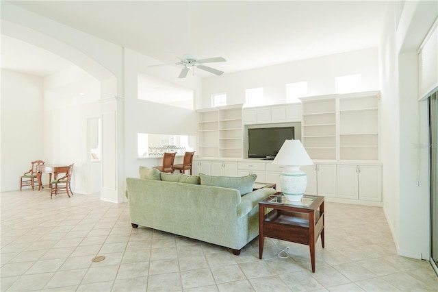 tiled living room with a high ceiling and ceiling fan