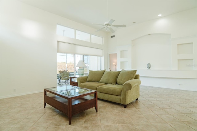 living room featuring ceiling fan, built in features, a high ceiling, and light tile patterned flooring