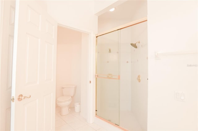 bathroom featuring tile patterned floors, a shower with door, and toilet