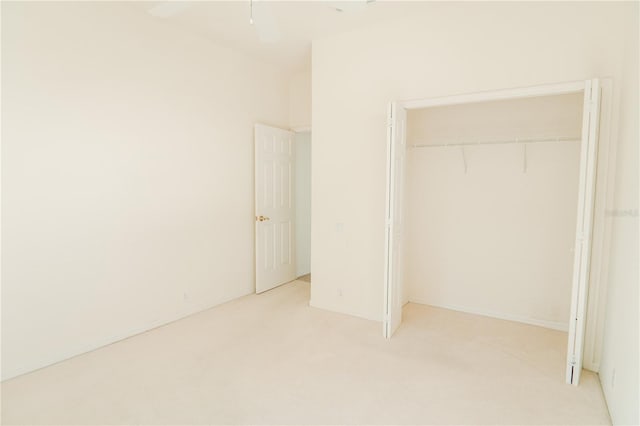 unfurnished bedroom featuring light colored carpet and a closet