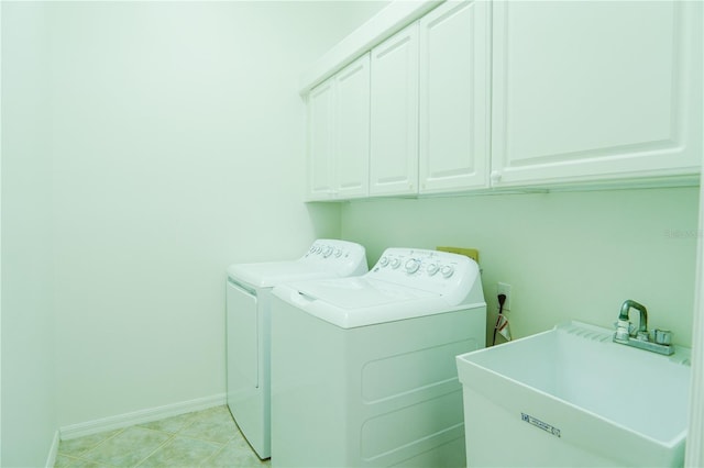 laundry area with sink, light tile patterned floors, washer and clothes dryer, and cabinets