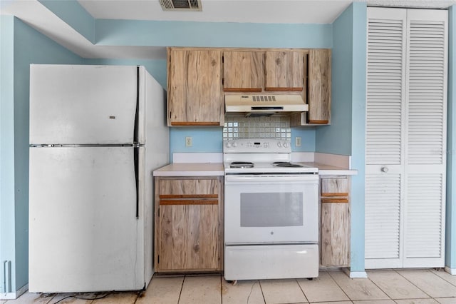 kitchen with tasteful backsplash, light tile patterned floors, and white appliances