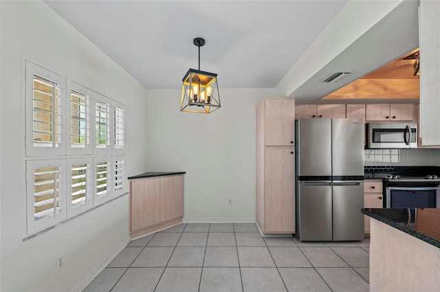 kitchen with pendant lighting, light tile patterned floors, light brown cabinets, and appliances with stainless steel finishes