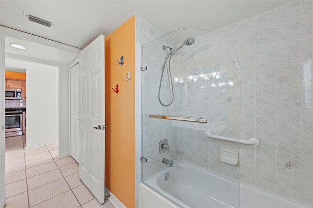 bathroom with tiled shower / bath combo and tile patterned floors