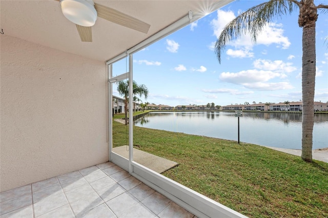 unfurnished sunroom featuring a water view and ceiling fan