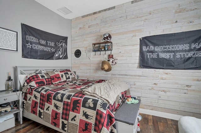 bedroom featuring dark hardwood / wood-style floors and wooden walls