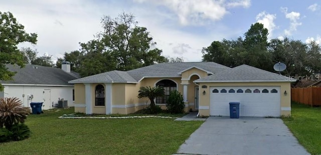 single story home with central AC, a garage, and a front lawn