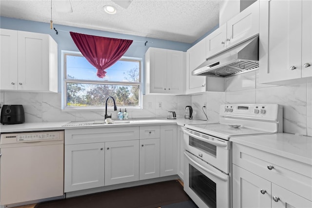 kitchen featuring sink, white cabinetry, a textured ceiling, white appliances, and backsplash