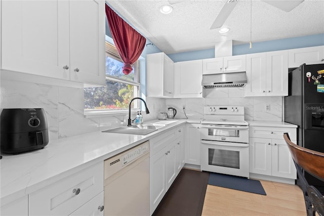 kitchen featuring white cabinetry, white appliances, sink, and exhaust hood