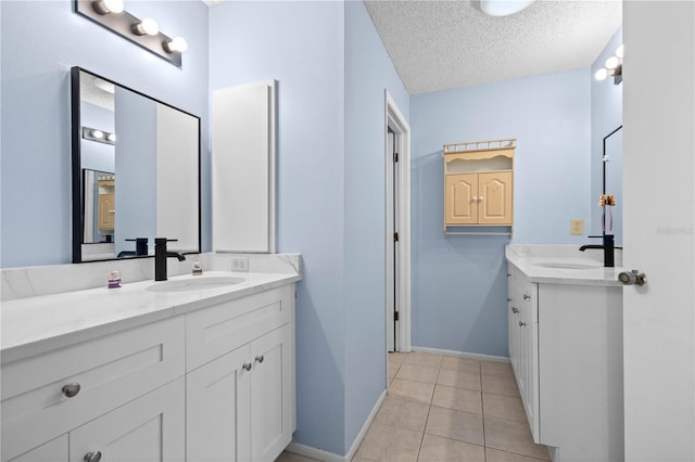 bathroom featuring tile patterned flooring, vanity, and a textured ceiling