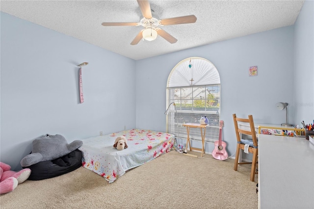 carpeted bedroom featuring ceiling fan and a textured ceiling