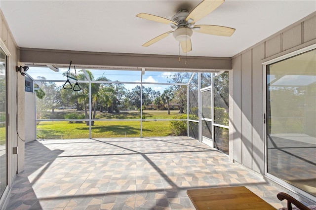 unfurnished sunroom featuring ceiling fan