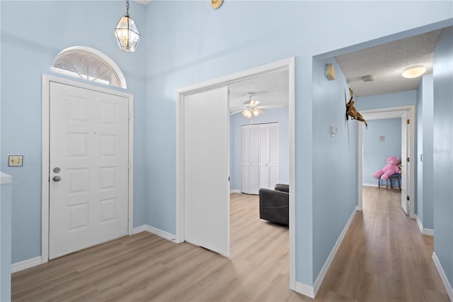 entrance foyer featuring a textured ceiling, wood finished floors, and baseboards