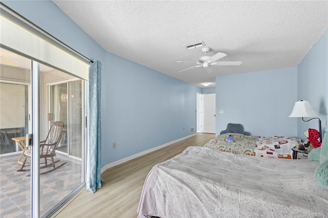 bedroom featuring visible vents, ceiling fan, wood finished floors, access to outside, and a textured ceiling