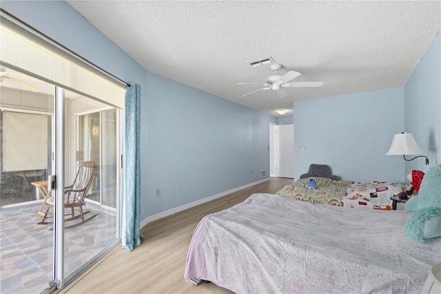 bedroom with access to exterior, visible vents, ceiling fan, a textured ceiling, and wood finished floors