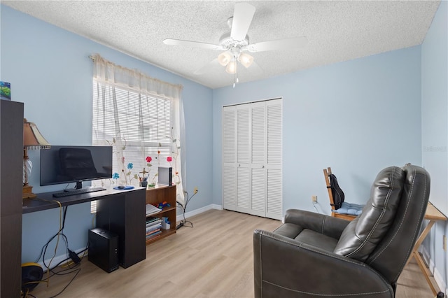 home office with ceiling fan, a textured ceiling, baseboards, and wood finished floors