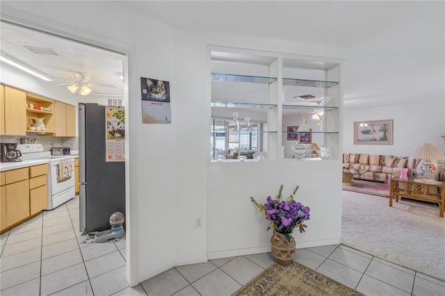 interior space featuring stainless steel fridge, ceiling fan, light tile patterned flooring, white electric stove, and light brown cabinets