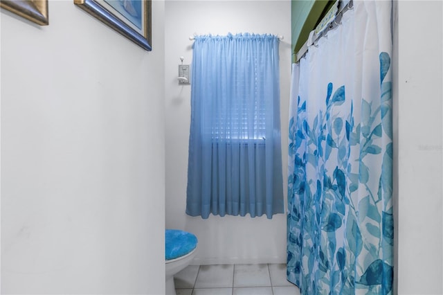 bathroom featuring tile patterned flooring, curtained shower, and toilet