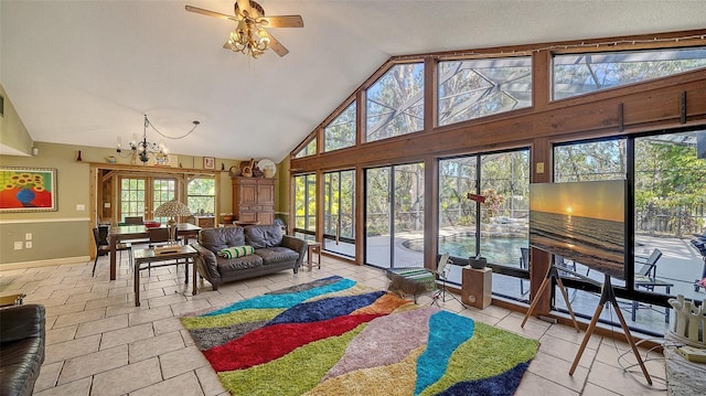 tiled living room featuring ceiling fan with notable chandelier and high vaulted ceiling