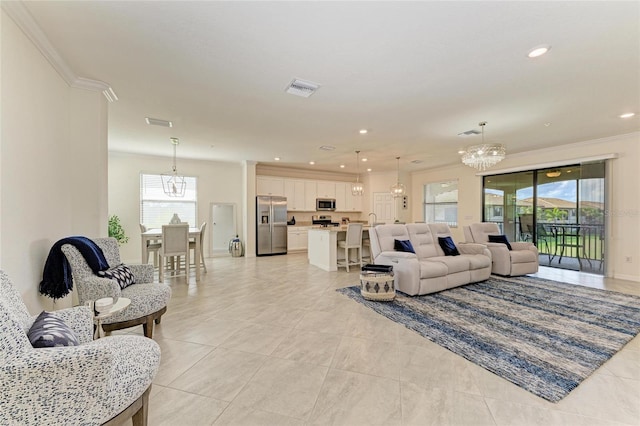 living room with crown molding, light tile patterned flooring, and a notable chandelier