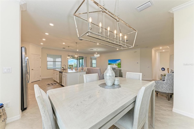 dining room with crown molding, light tile patterned floors, sink, and a notable chandelier