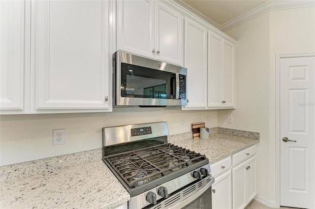 kitchen with stainless steel appliances, crown molding, white cabinets, and light stone counters