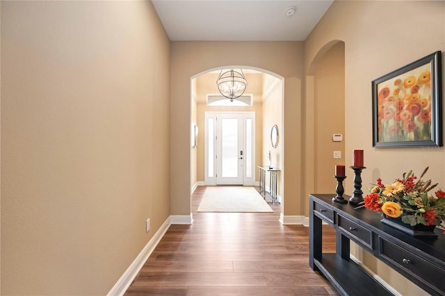 foyer with dark hardwood / wood-style floors and an inviting chandelier