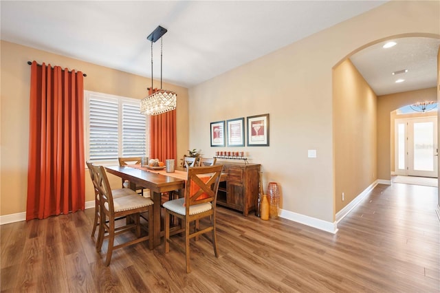 dining space with an inviting chandelier and wood-type flooring