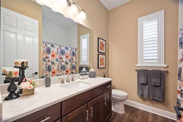 bathroom with vanity, hardwood / wood-style flooring, curtained shower, and toilet