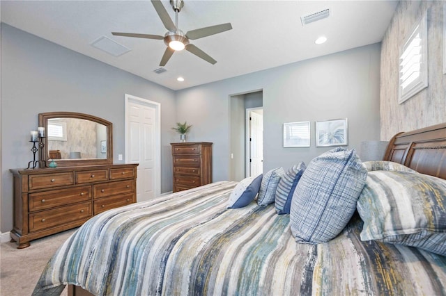 bedroom with multiple windows, light carpet, and ceiling fan