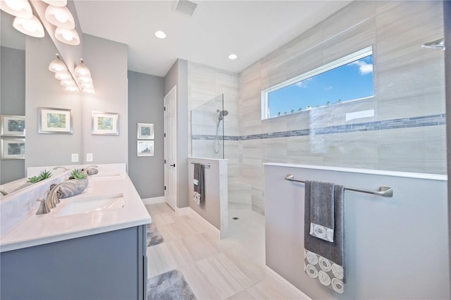 bathroom with vanity and a tile shower