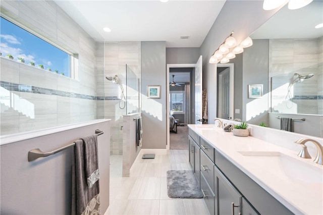 bathroom with vanity, tile patterned flooring, and a tile shower