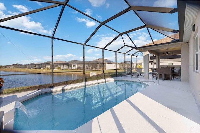 view of pool featuring ceiling fan, a water view, glass enclosure, a patio area, and pool water feature