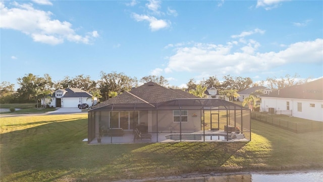 rear view of house featuring a water view, a lawn, a lanai, a swimming pool, and a patio