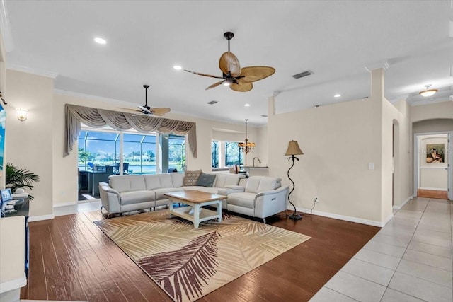 living area with ornamental molding, recessed lighting, visible vents, and wood finished floors