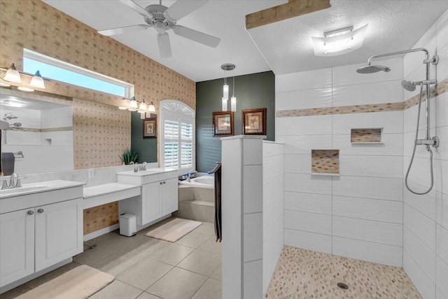 bathroom featuring a textured ceiling, two vanities, a sink, tiled shower, and wallpapered walls