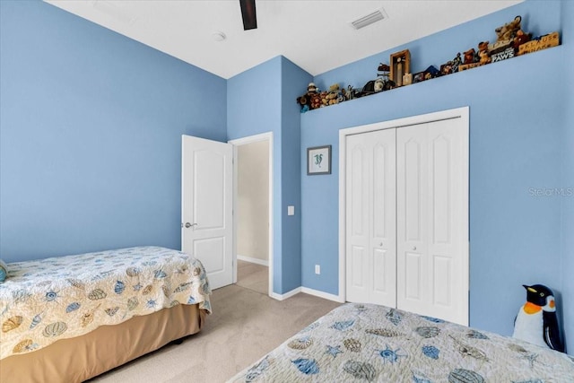 carpeted bedroom with a ceiling fan, a closet, visible vents, and baseboards