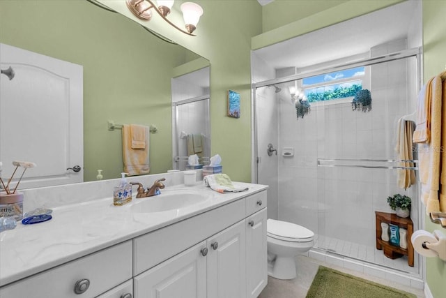 bathroom featuring a stall shower, tile patterned flooring, vanity, and toilet