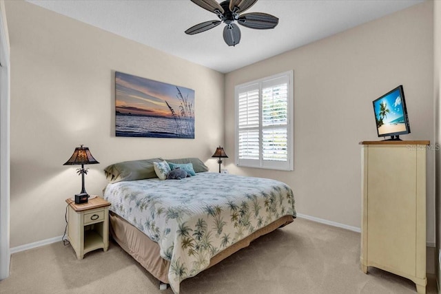 bedroom featuring light carpet, ceiling fan, and baseboards